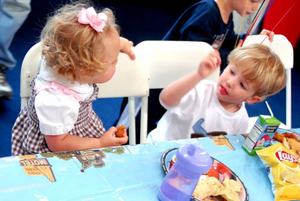 The birthday boy saves a seat next to him for his cousin, Emma Kate