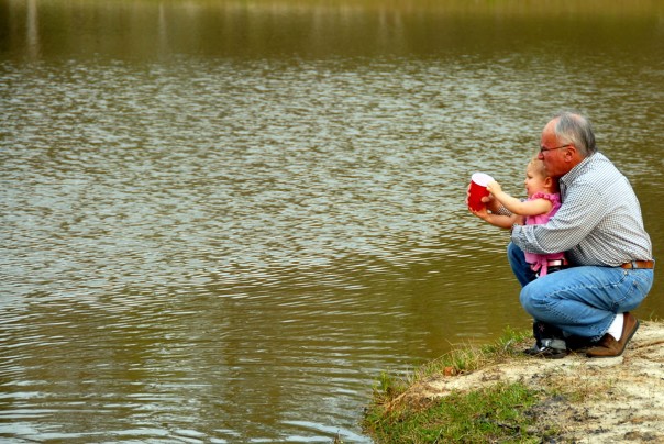 Grandpa helping EK feed the fish