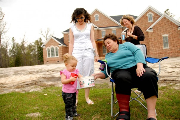 Donette and Alison watch Emma Kate get her 10th cup of fish food from Grandma