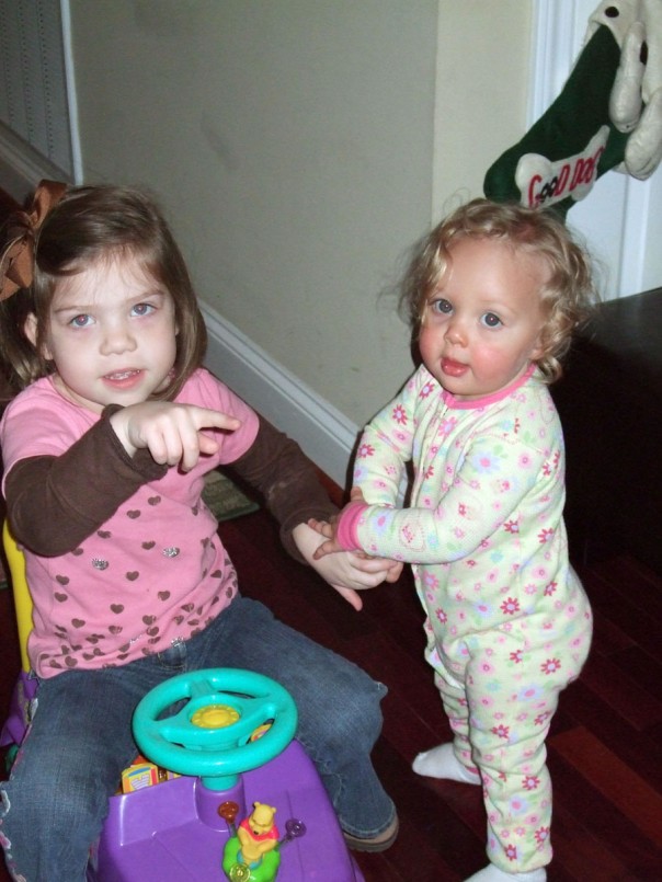 Megan showing EK how a big girl rides a Pooh car
